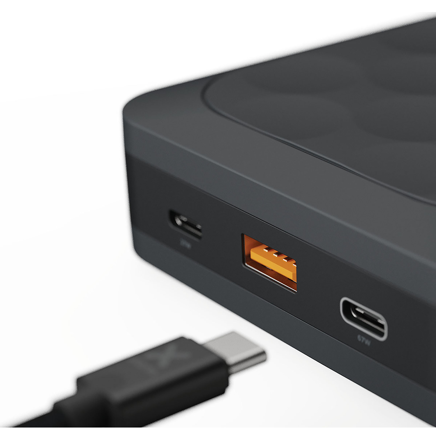 A black USB-C cable approaches a black power bank port.