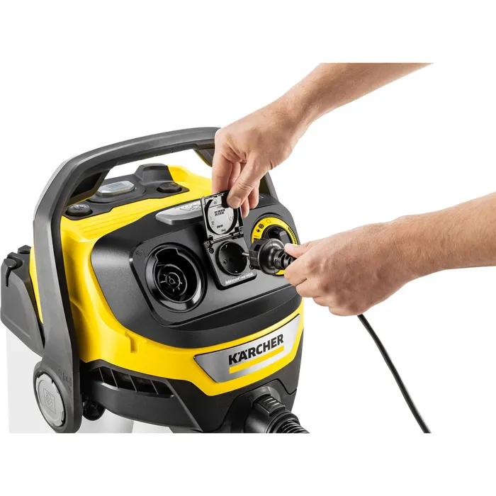 Ręce wpinają czarną wtyczkę do żółtej maszyny Kärcher.