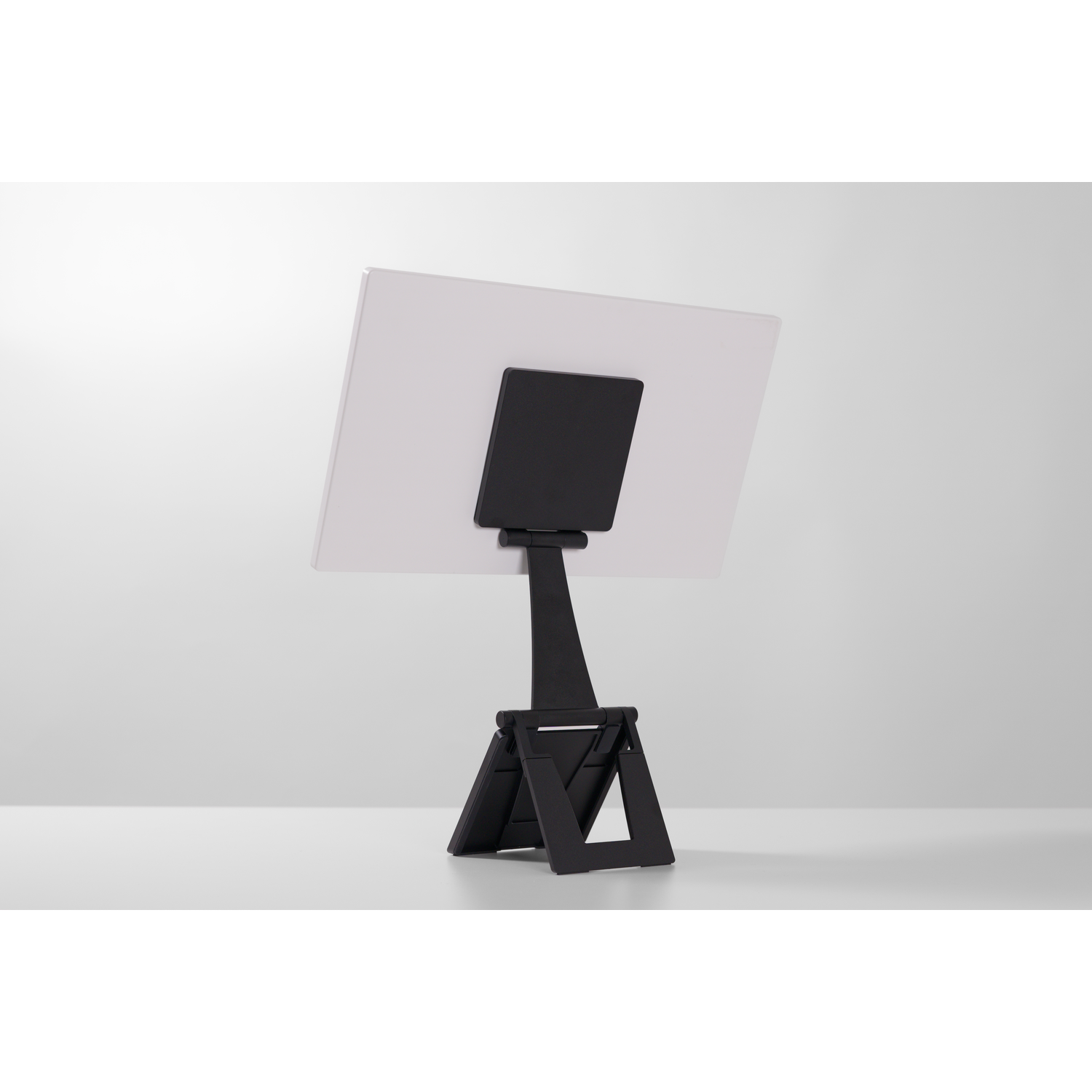 A black tablet stand holding a white tablet, viewed from the back.