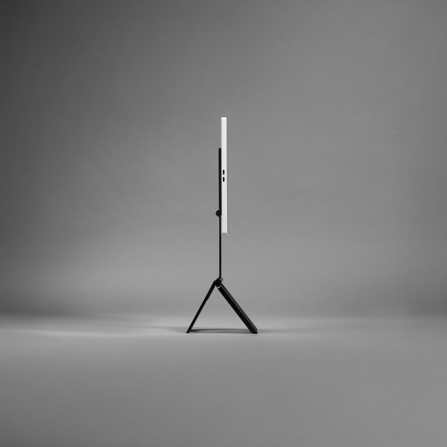 A white screen is on a black stand against a gray background.