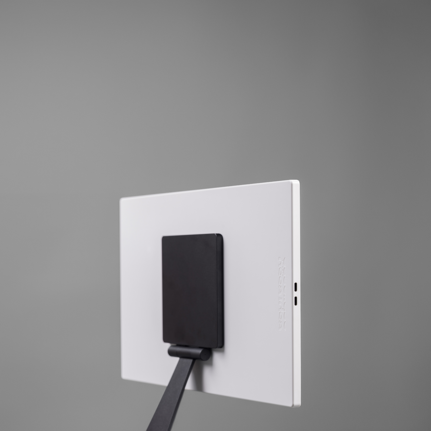 Back of a white display with black stand, gray background.