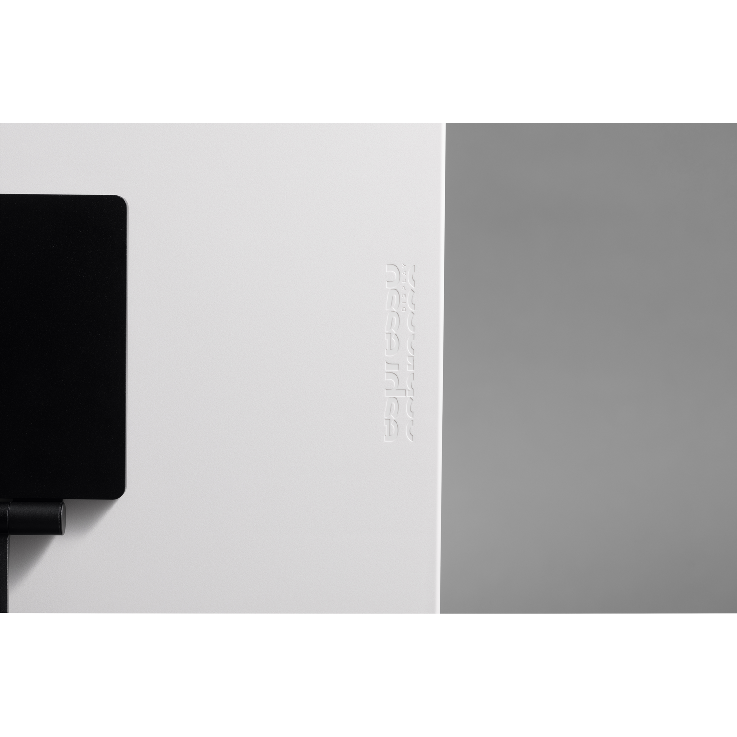 A black element on the left, next to a white field with embossed text.