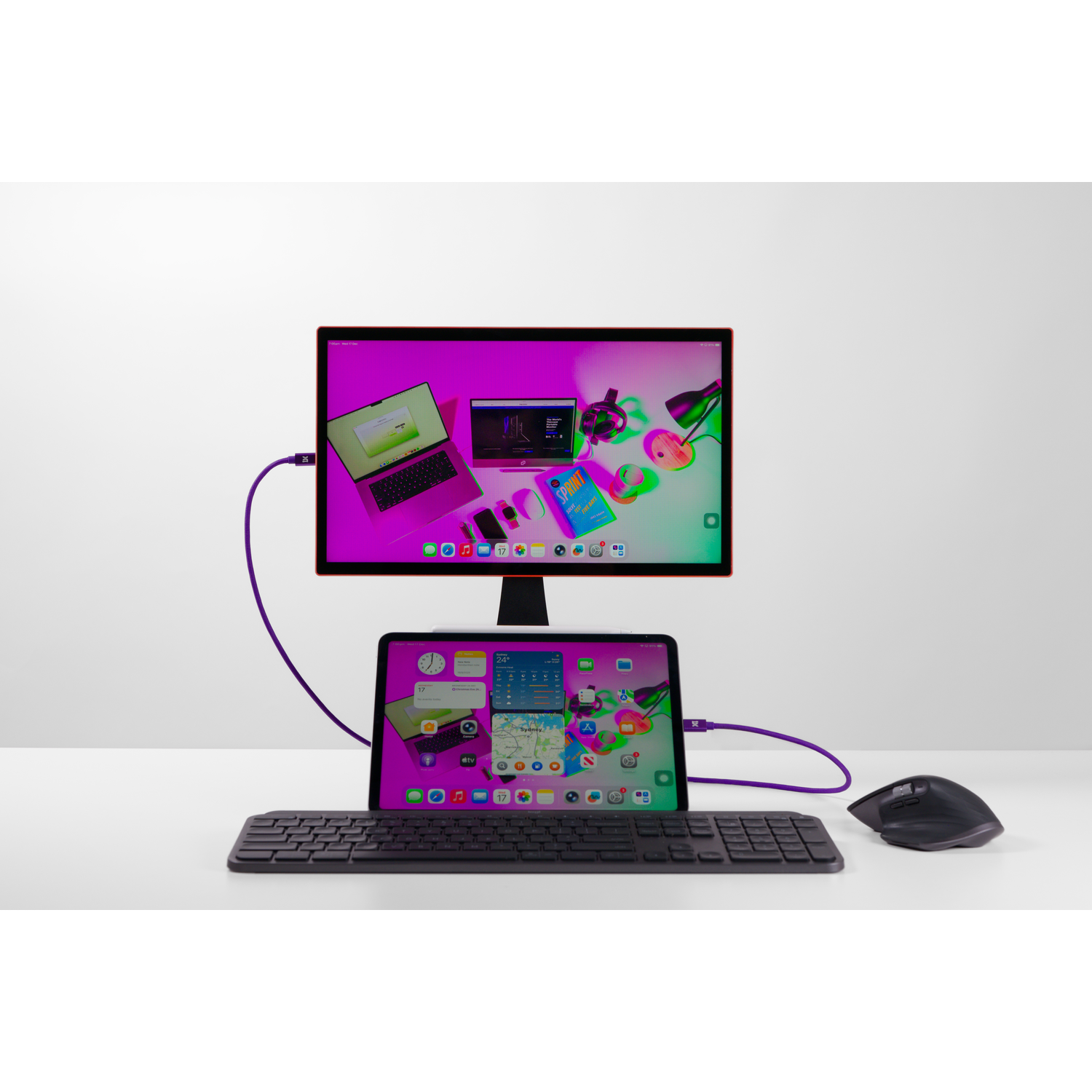 A monitor and tablet display devices connected by purple cables, with keyboard and mouse.