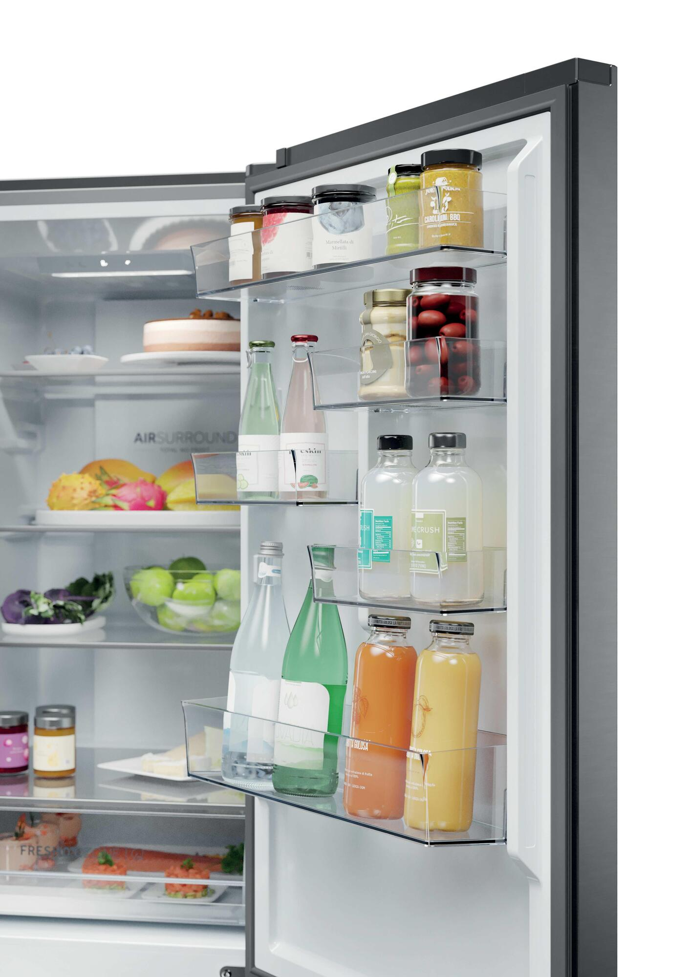 Refrigerador abierto lleno de frascos, botellas, frutas, pastel y verduras.