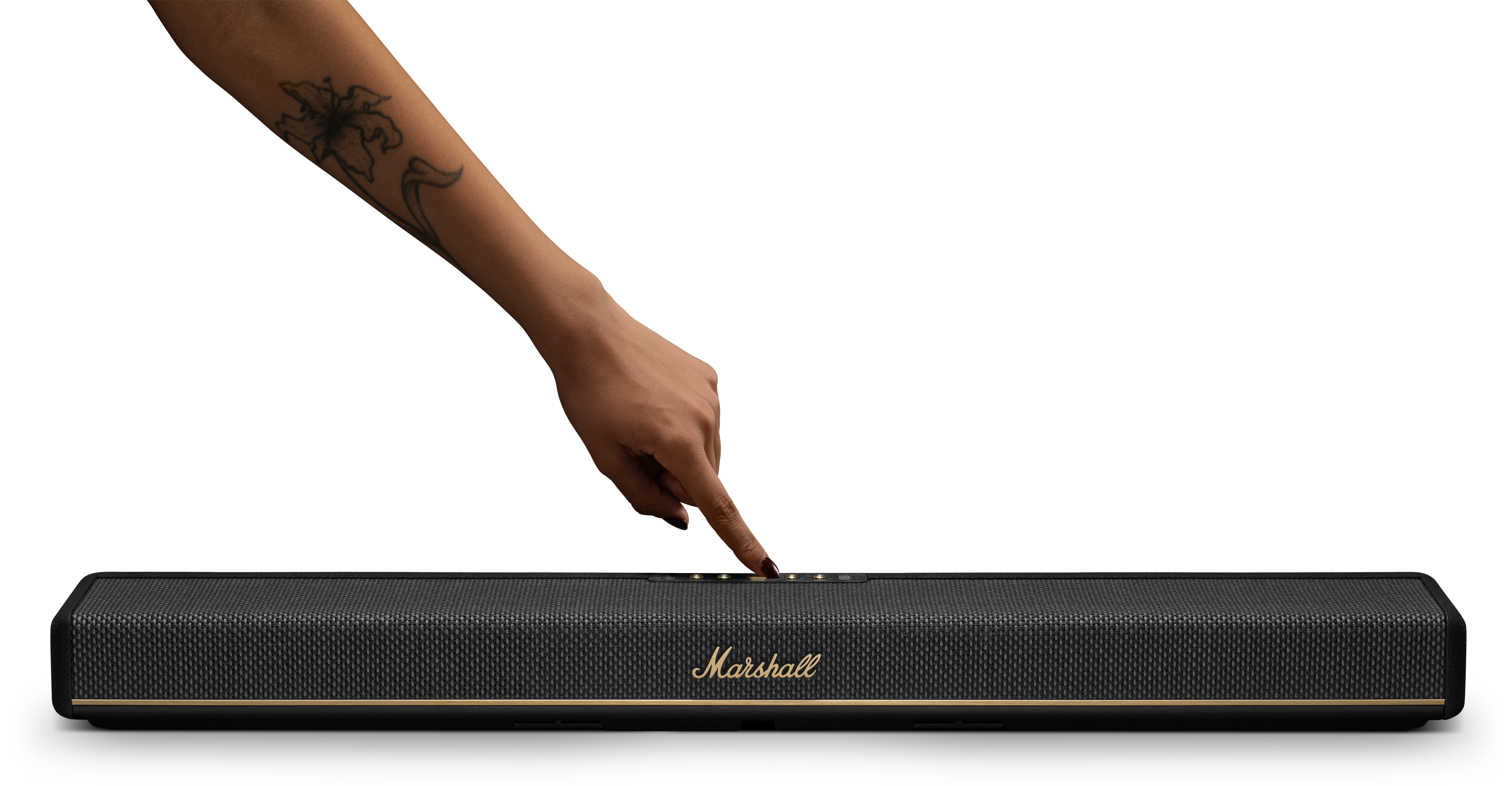 Ręka z tatuażem naciska czarny głośnik Marshall. Widok szczegółowy.