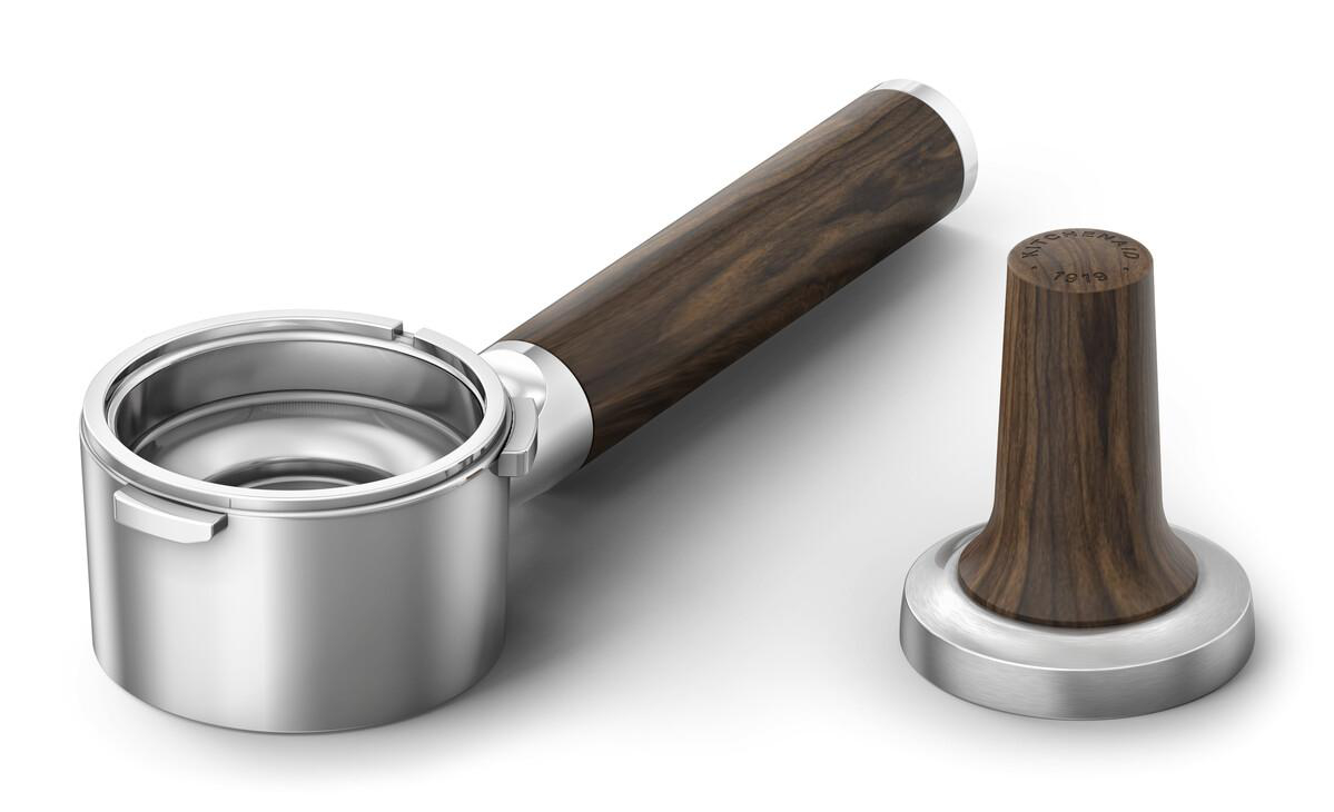 Ein silberner Siebträger und ein Holz-Tamper mit silbernem Sockel.