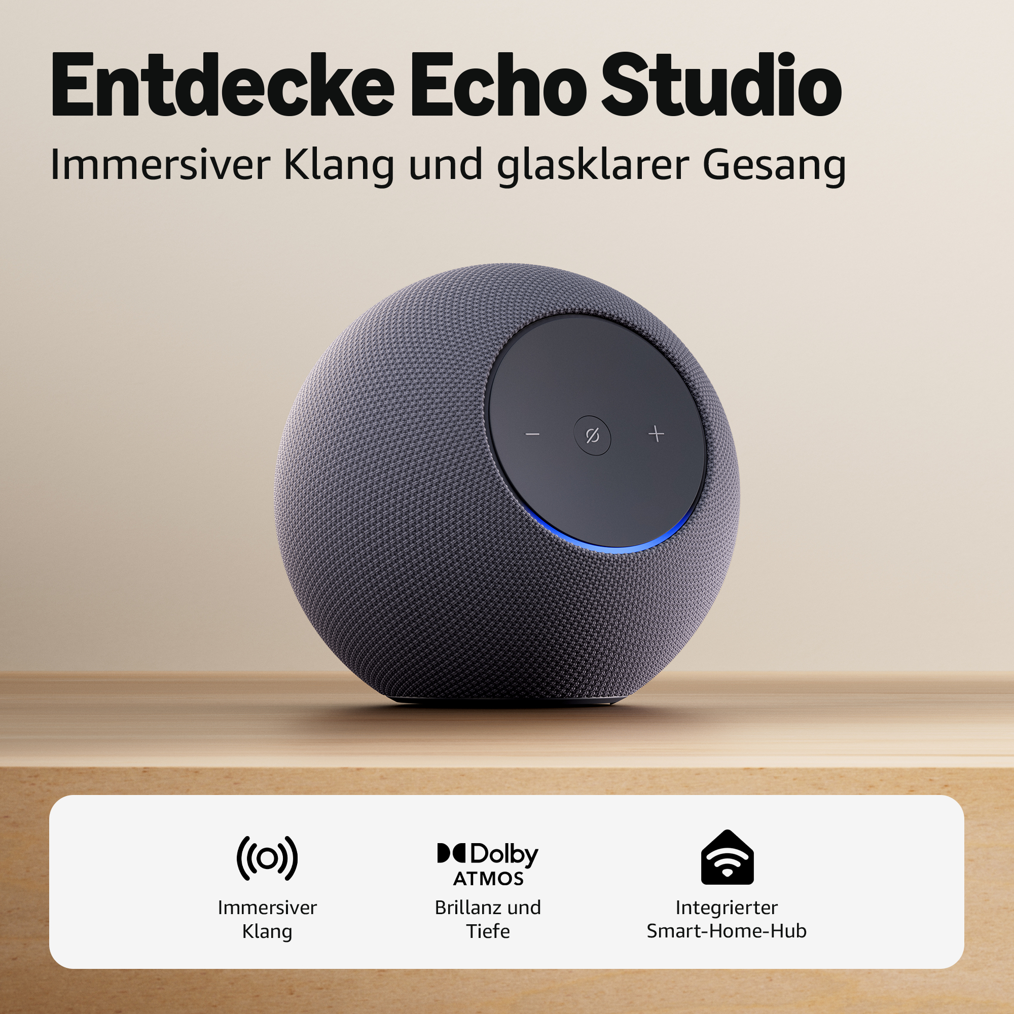 Ein grauer Echo Studio Lautsprecher auf einem Holztisch.