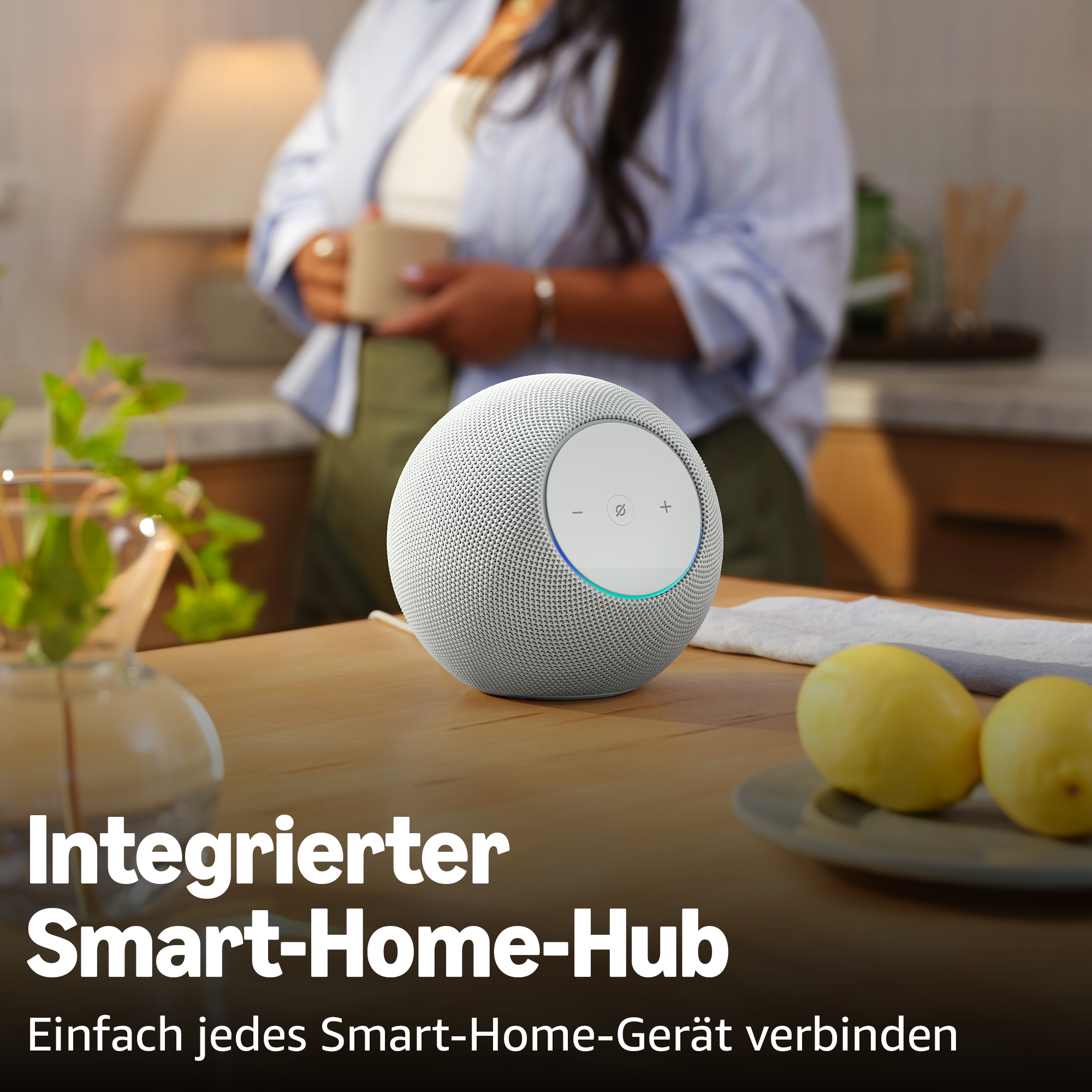 Ein weißer Smart Speaker steht auf einem Holztisch, daneben Zitronen.