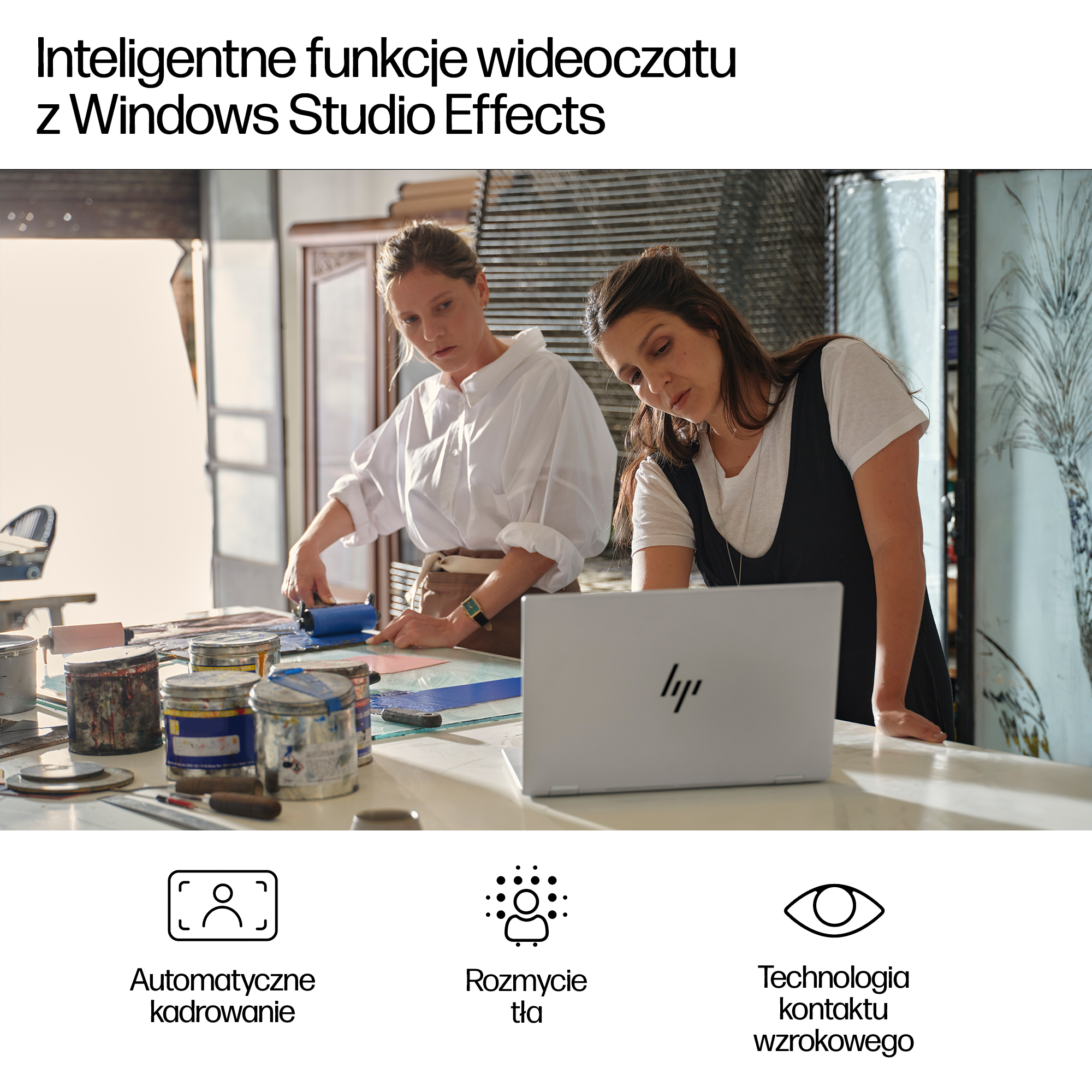 Dwie kobiety pracują przy stole z farbami i laptopem w studiu.