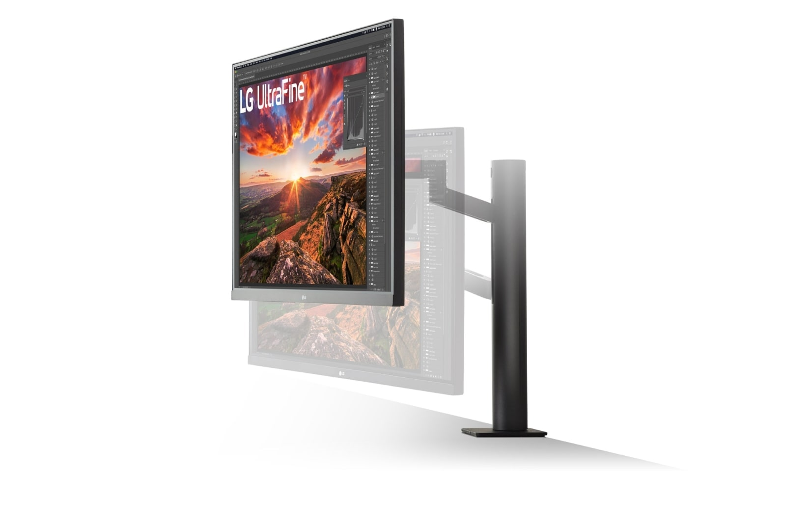 Monitor LG UltraFine stoi na czarnym stojaku. Ekran wyświetla górski krajobraz o zachodzie słońca.