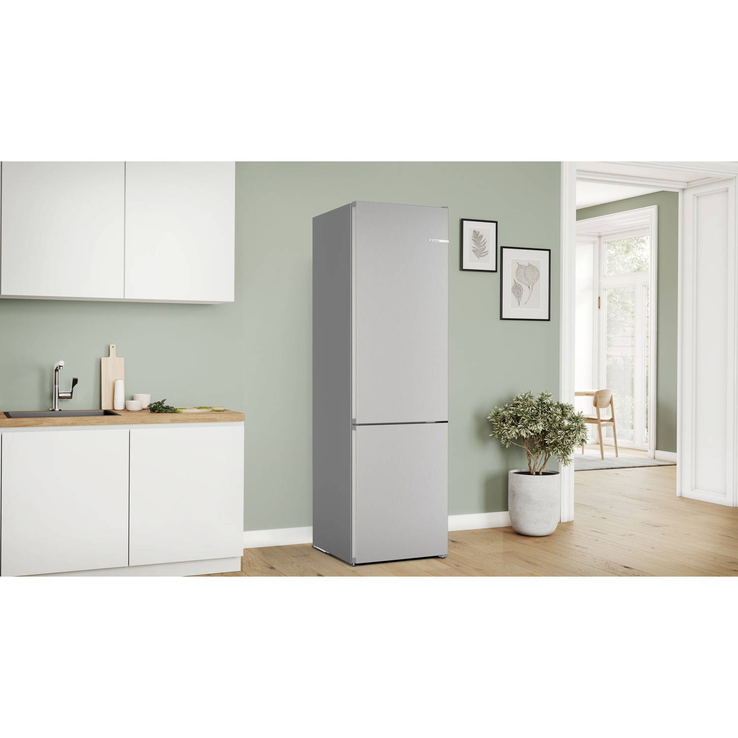 Cucina moderna con frigorifero argento, mobili bianchi, lavello e pianta in vaso.