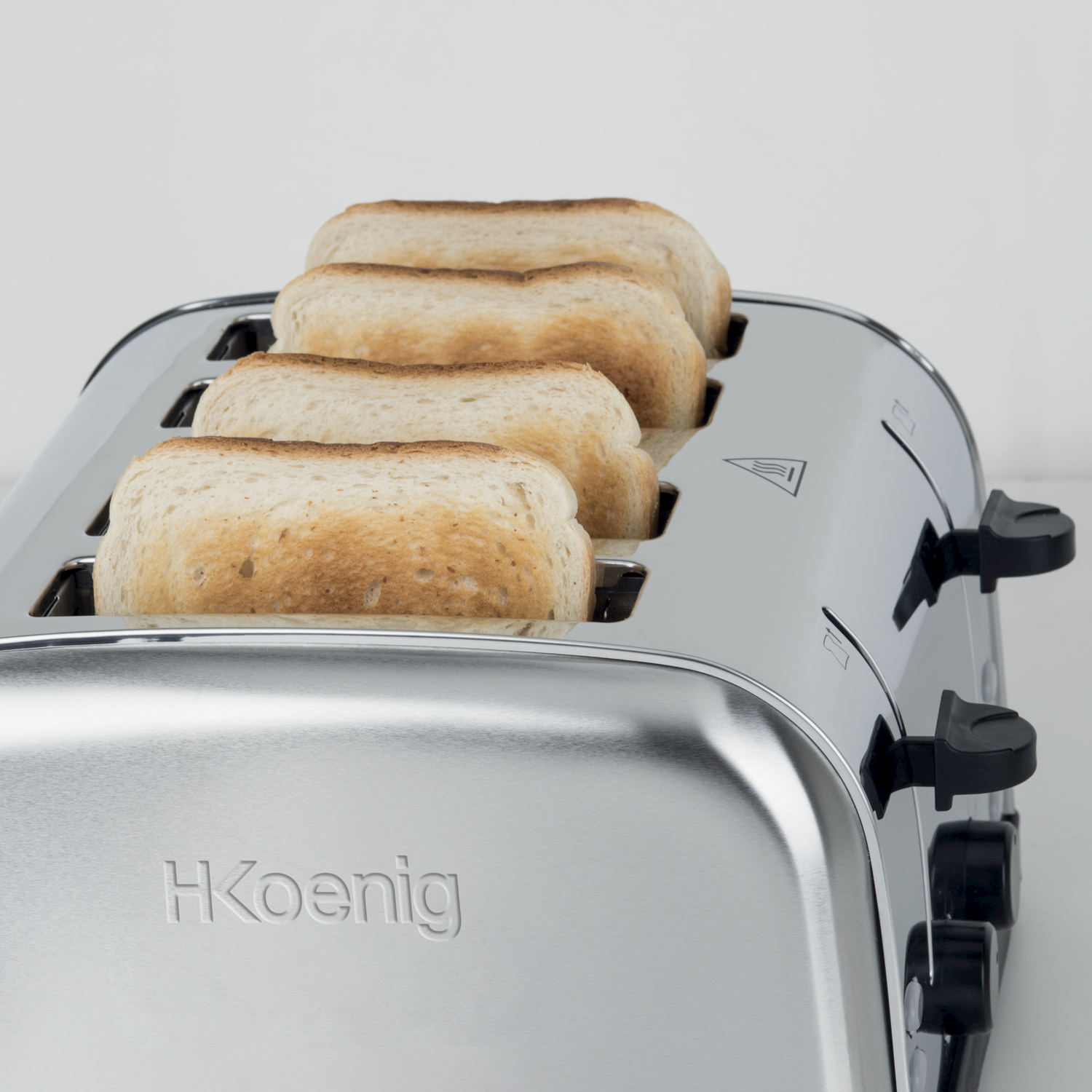 Un tostapane argentato con quattro fette di pane tostato.