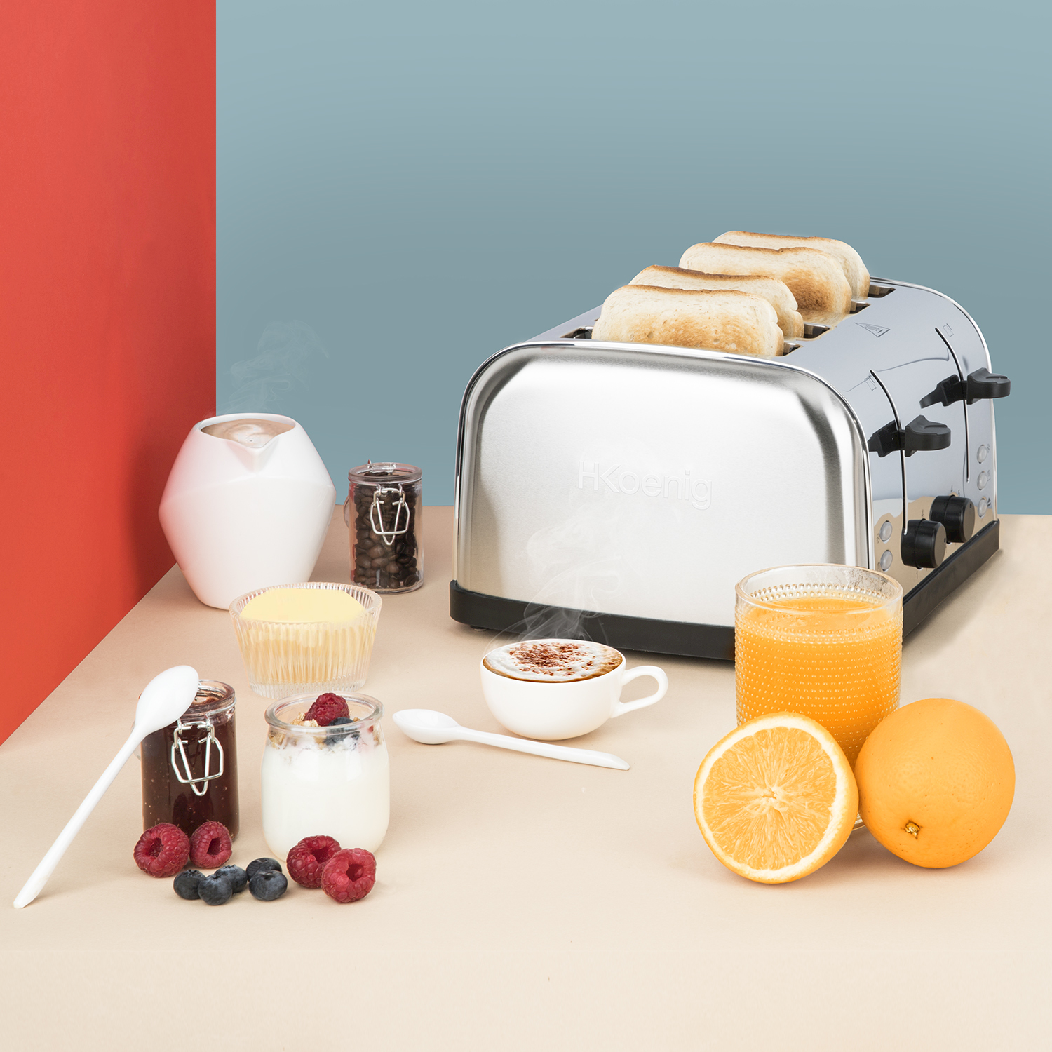 Un tostapane argento con pane, caffè, succo, frutta e marmellata.
