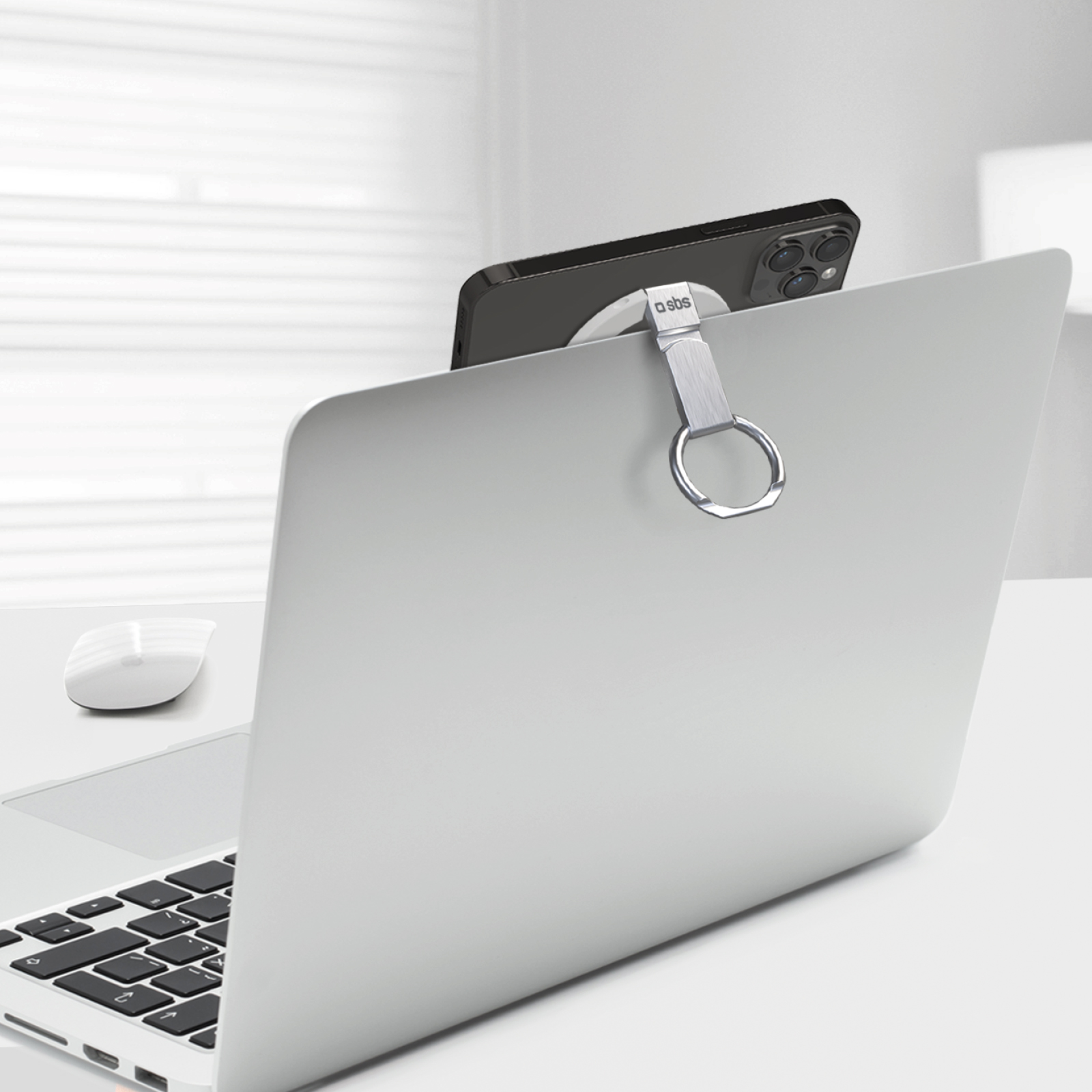 Ein schwarzes iPhone mit silbernem Ringhalter an einem Laptop befestigt.