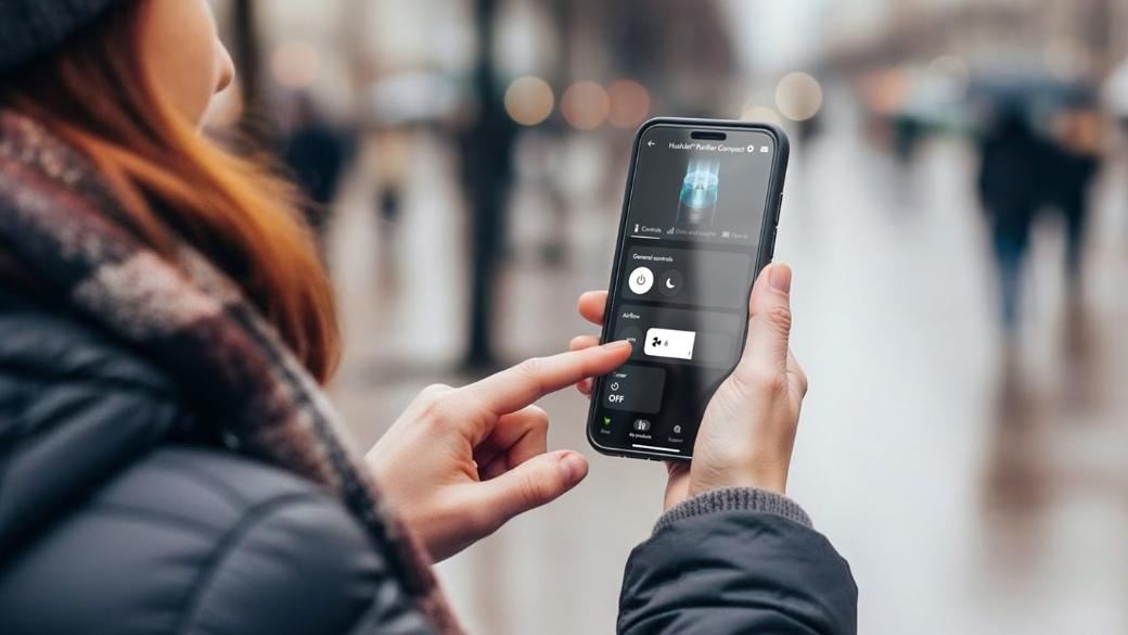 Personne utilisant une application smartphone pour les commandes du purificateur d'air en extérieur.