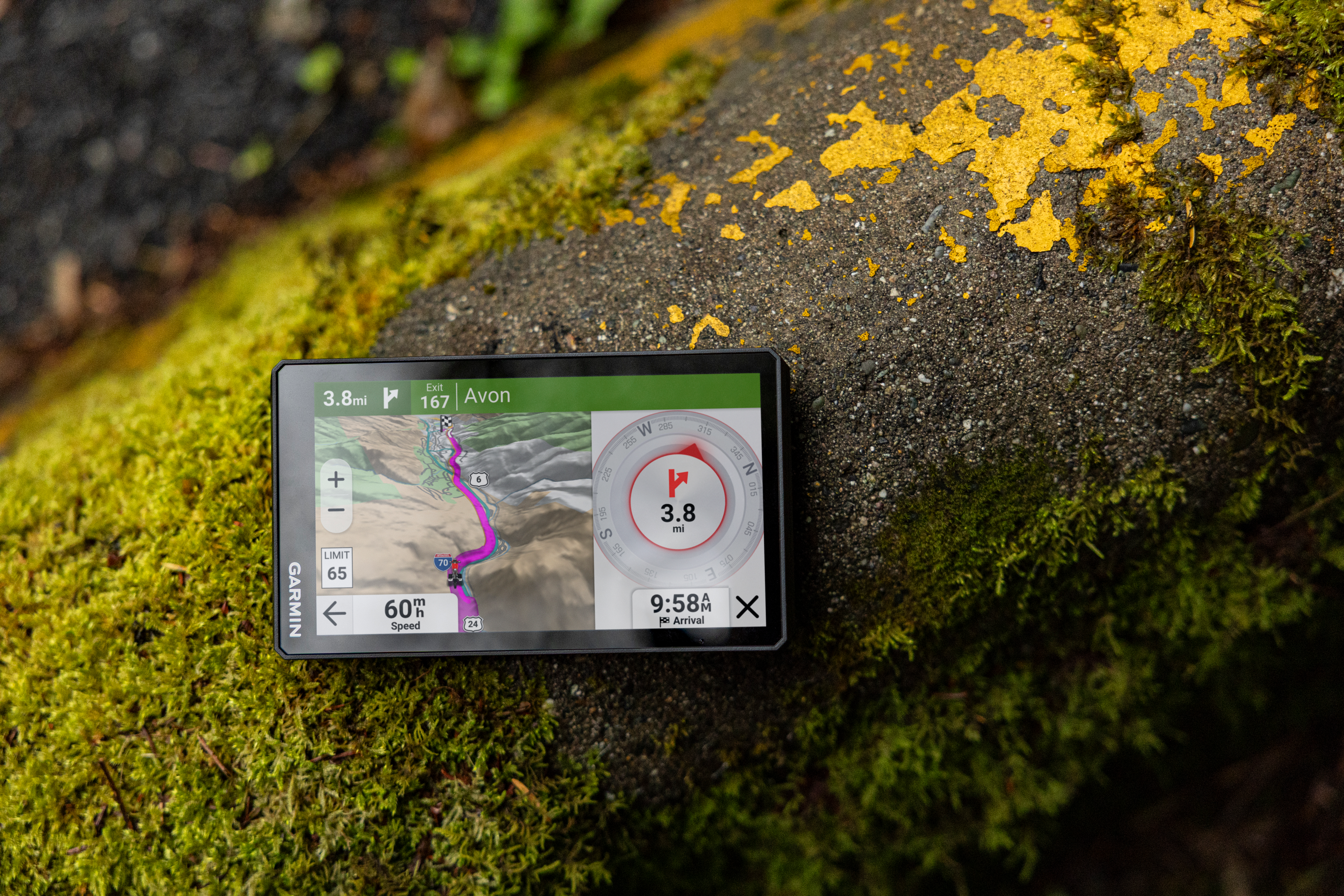 Navigatore Garmin su roccia muschiosa con segnaletica gialla.