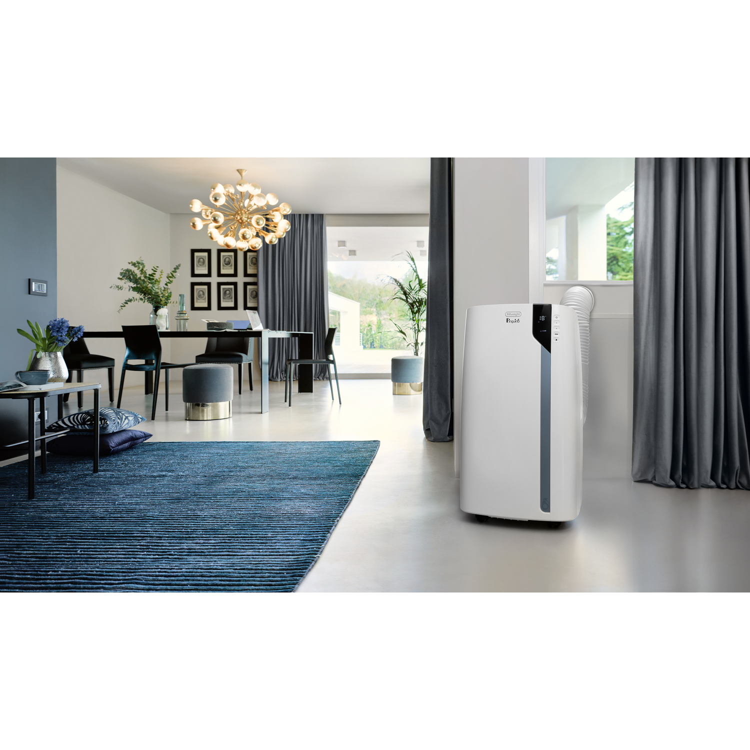 Een witte draagbare airconditioner staat in een moderne woonkamer met een blauw tapijt.