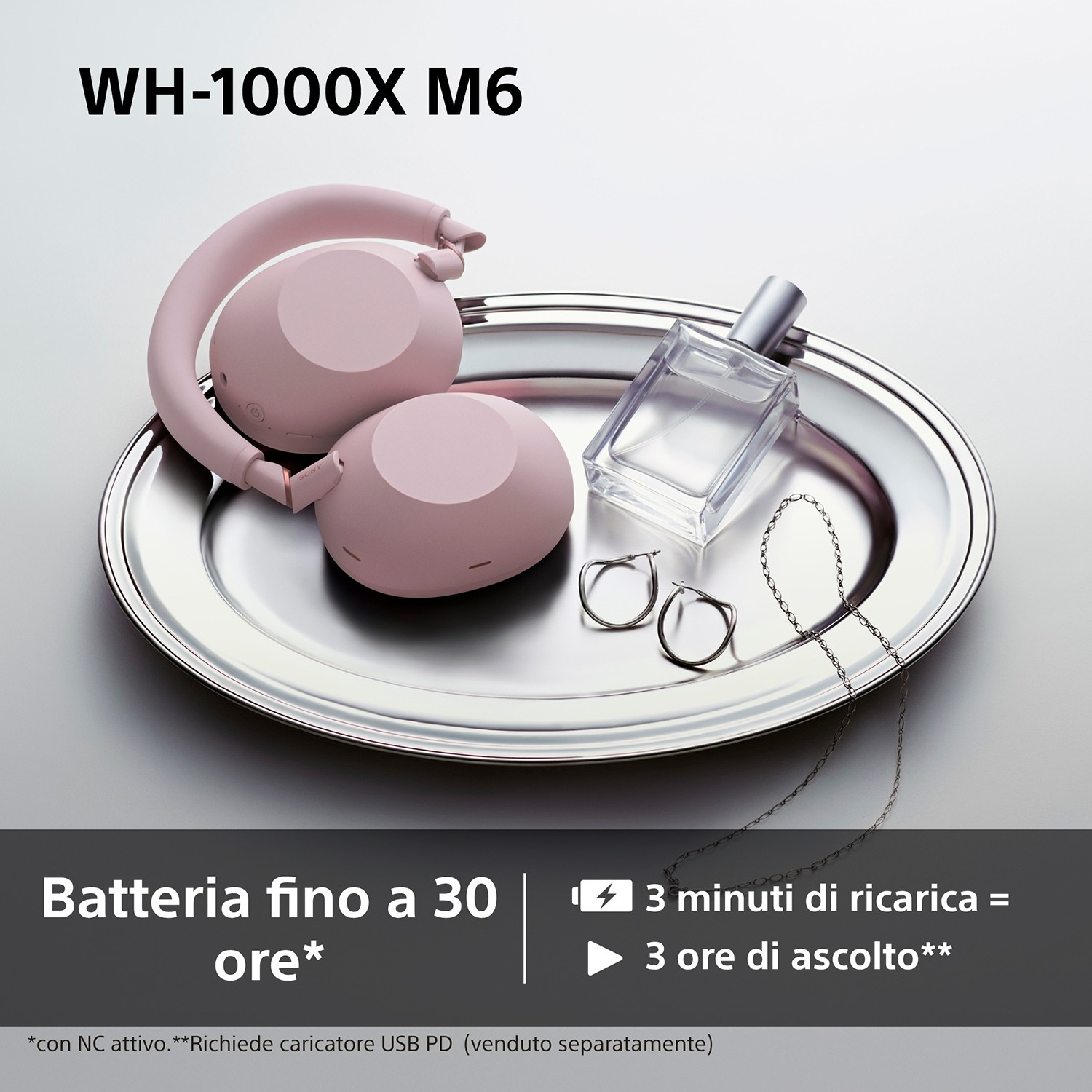 Cuffie rosa, boccetta di profumo e gioielli su un vassoio.