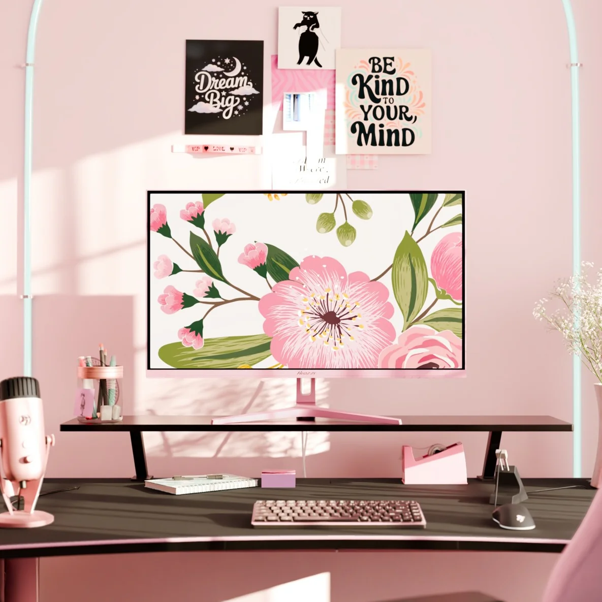 Un bureau rose avec un écran d'ordinateur affichant des fleurs.