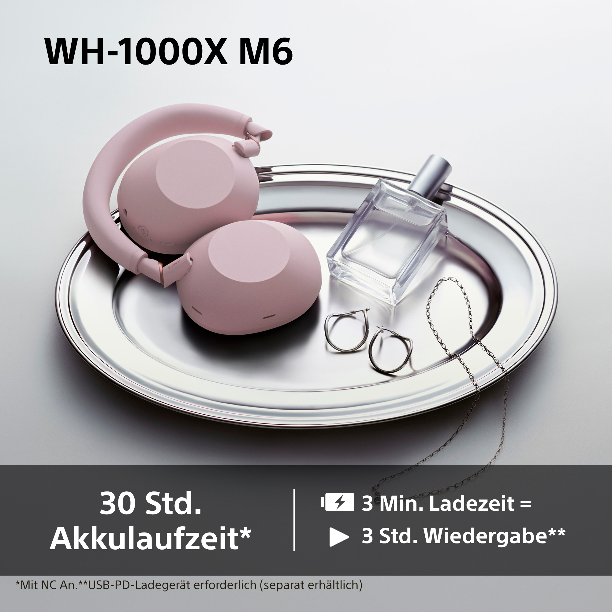 Eine rosafarbene Kopfhörer, Parfümflasche, Ringe und Kette auf einem Silberteller.