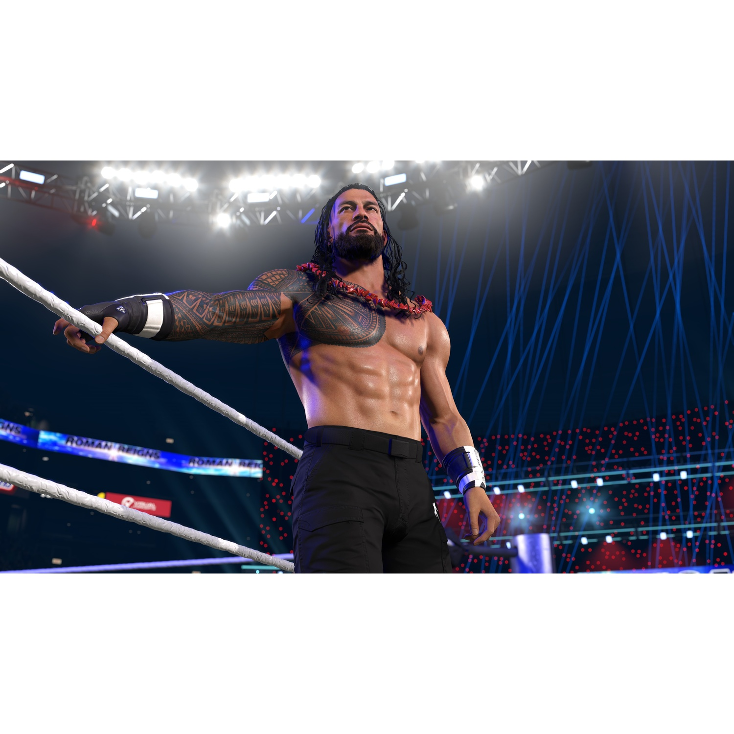 Un wrestler tatuato sta in un ring sotto le luci dello stadio.