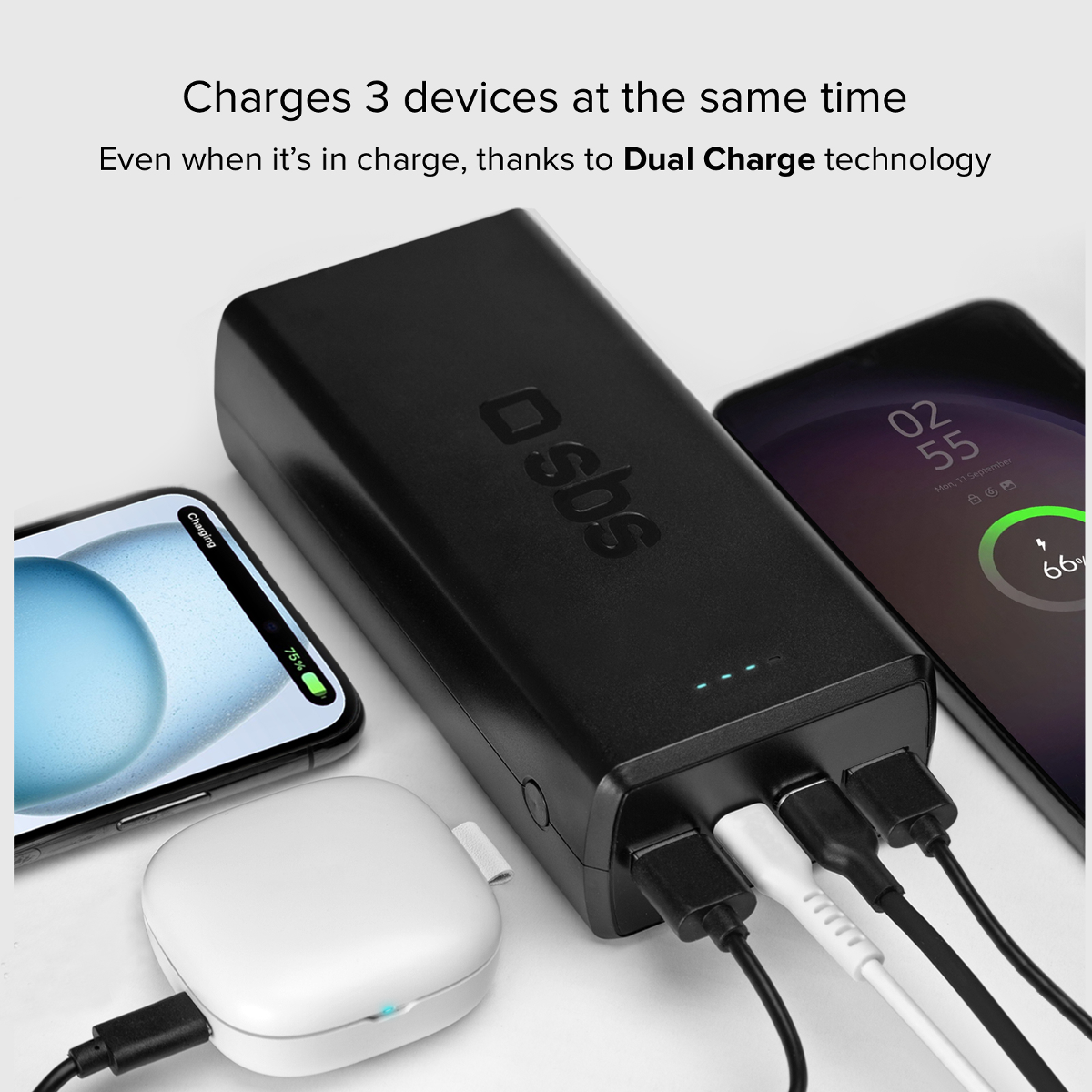 Schwarzes Powerbank lädt drei Geräte: zwei Handys und ein weißes Ladegerät.