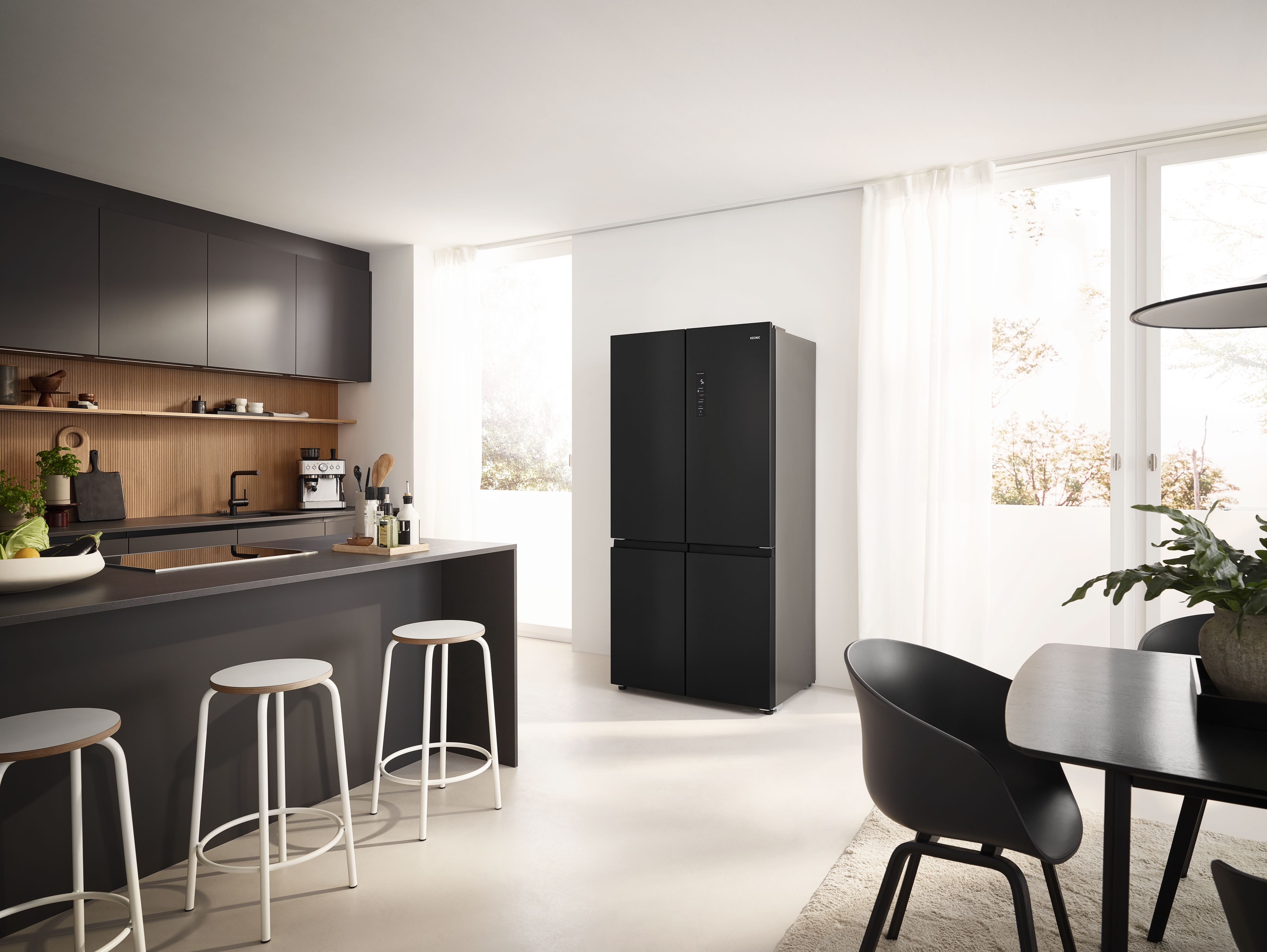 Moderne schwarze Küche mit Kühlschrank, Bar und Esstisch.