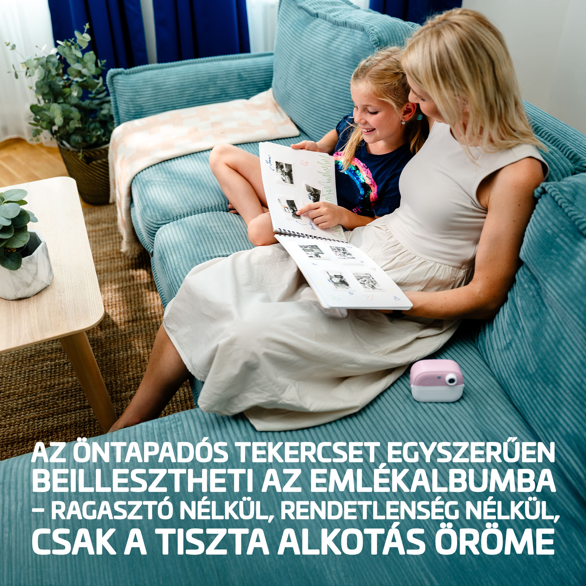 Nő és gyerek fotóalbumot nézeget egy türkiz kanapén.