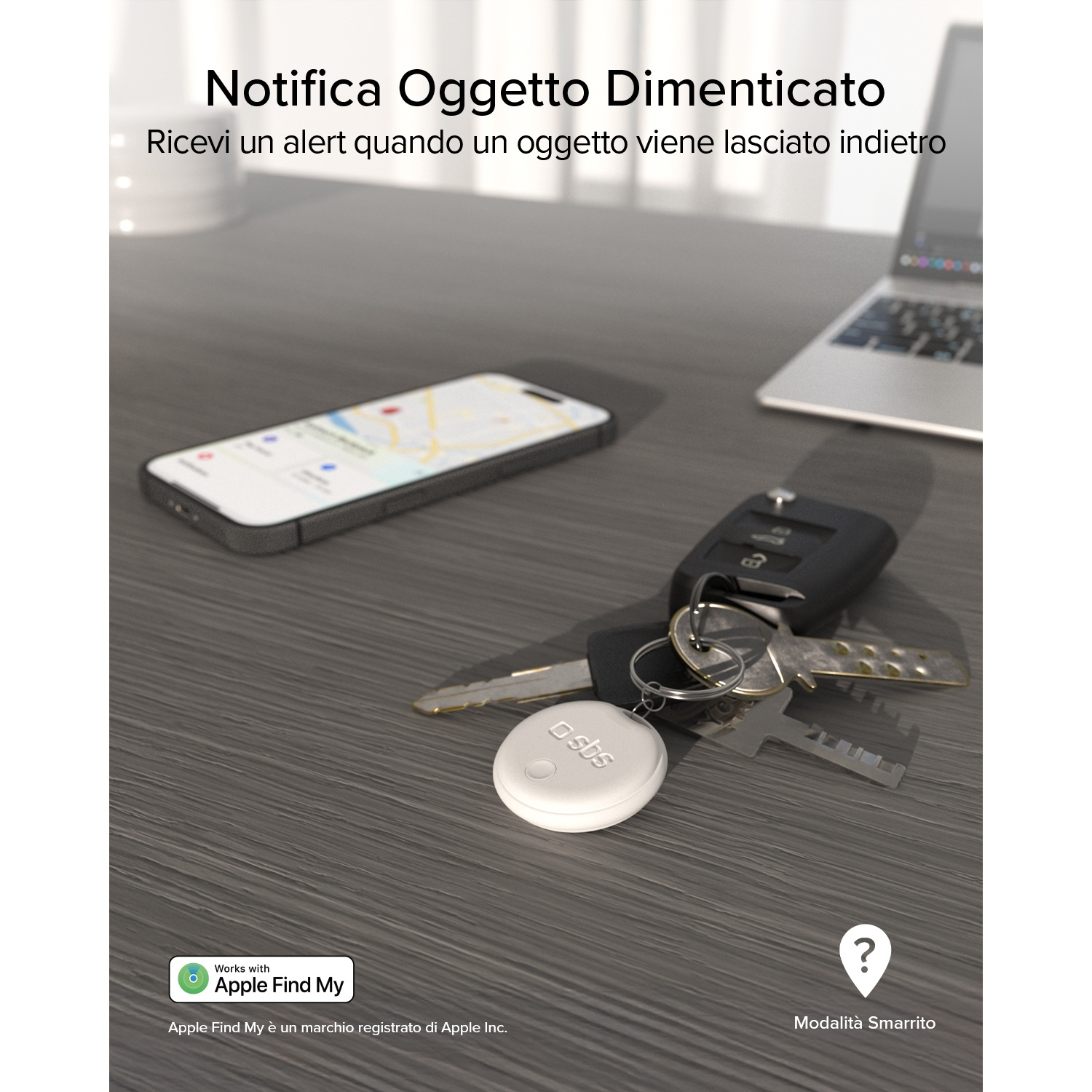 Un portachiavi bianco con scritta 'sbs' giace su una scrivania accanto a chiavi e smartphone.