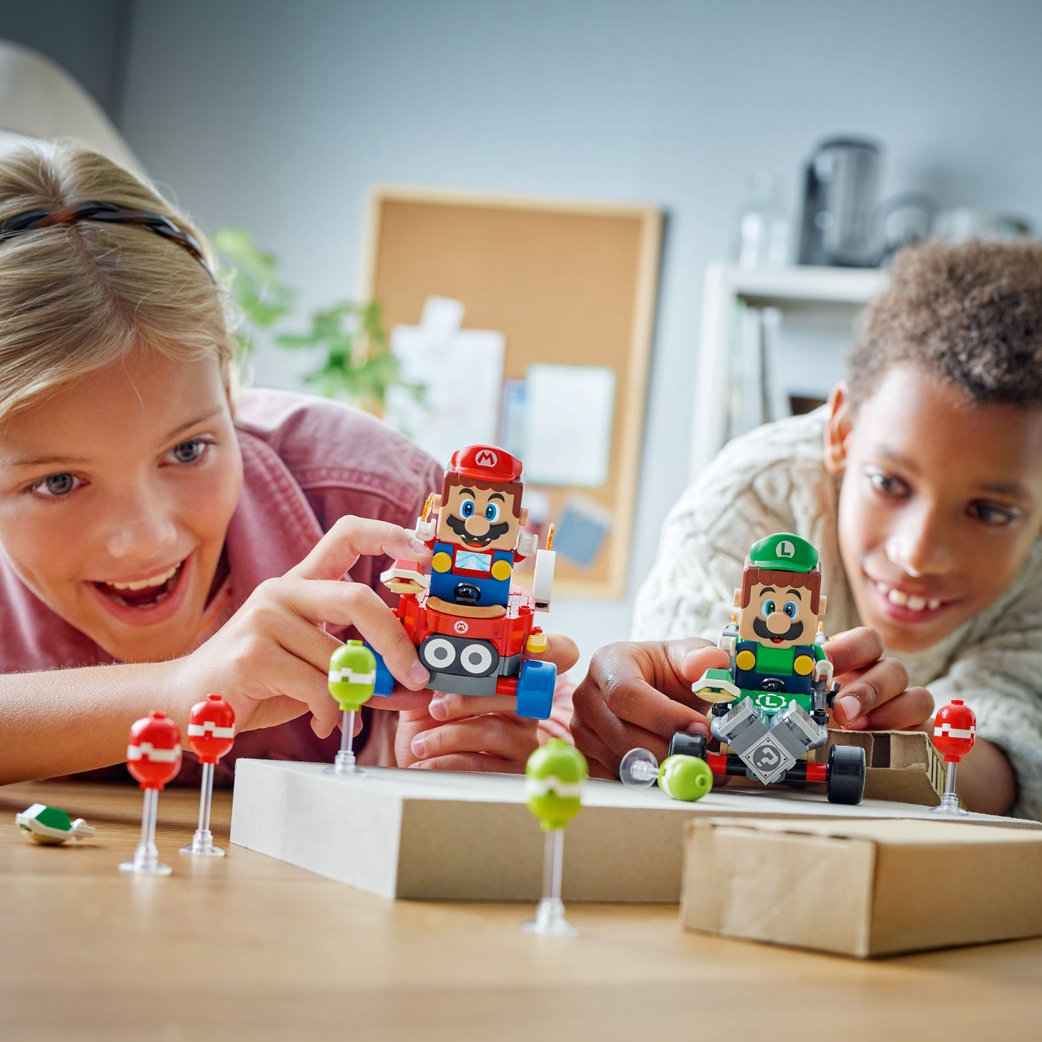 Two children build Lego figures of Mario and Luigi in go-karts.
