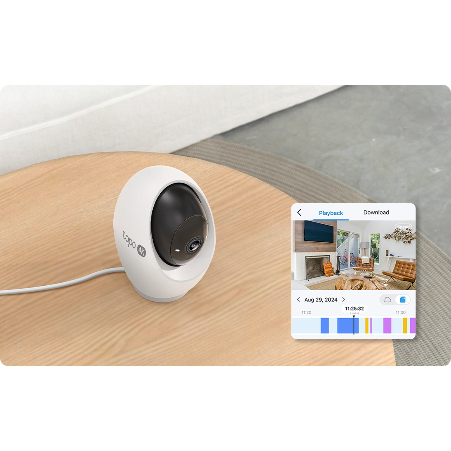 Witte beveiligingscamera op houten tafel naast smartphone met afspelen menu.