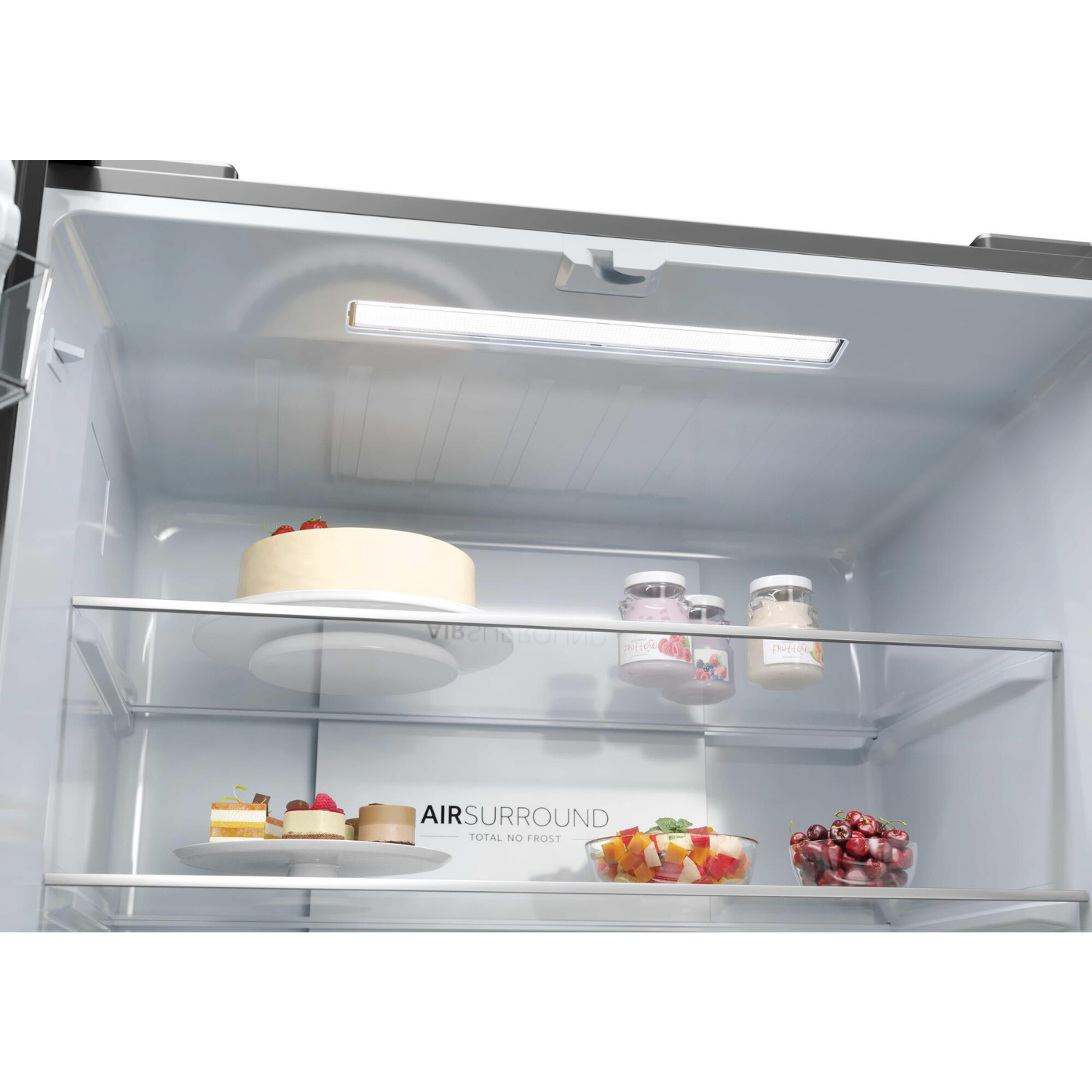 Interior de refrigerador con pastel, postres, ensalada de frutas, bayas y yogur.