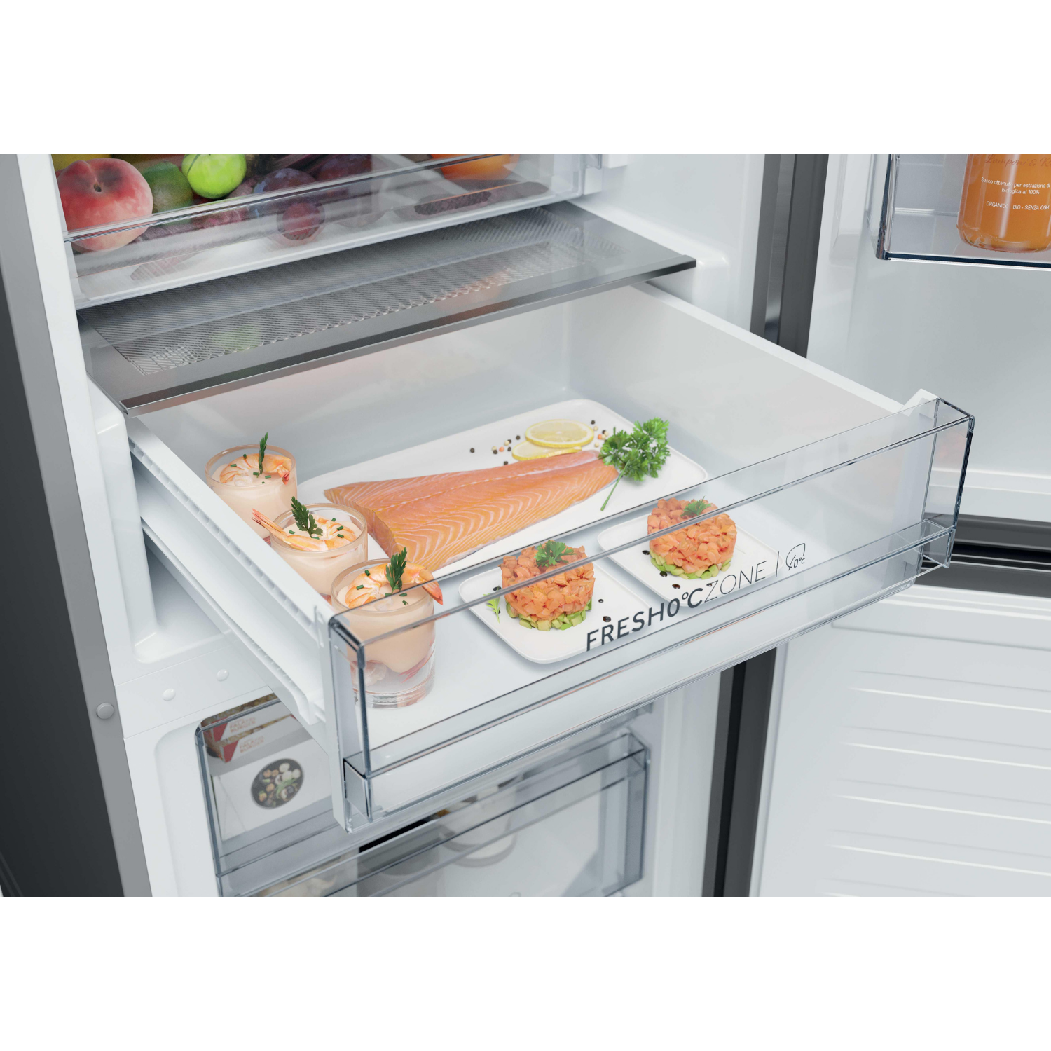 Un refrigerador abierto muestra un cajón con salmón, camarones y rodajas de limón.