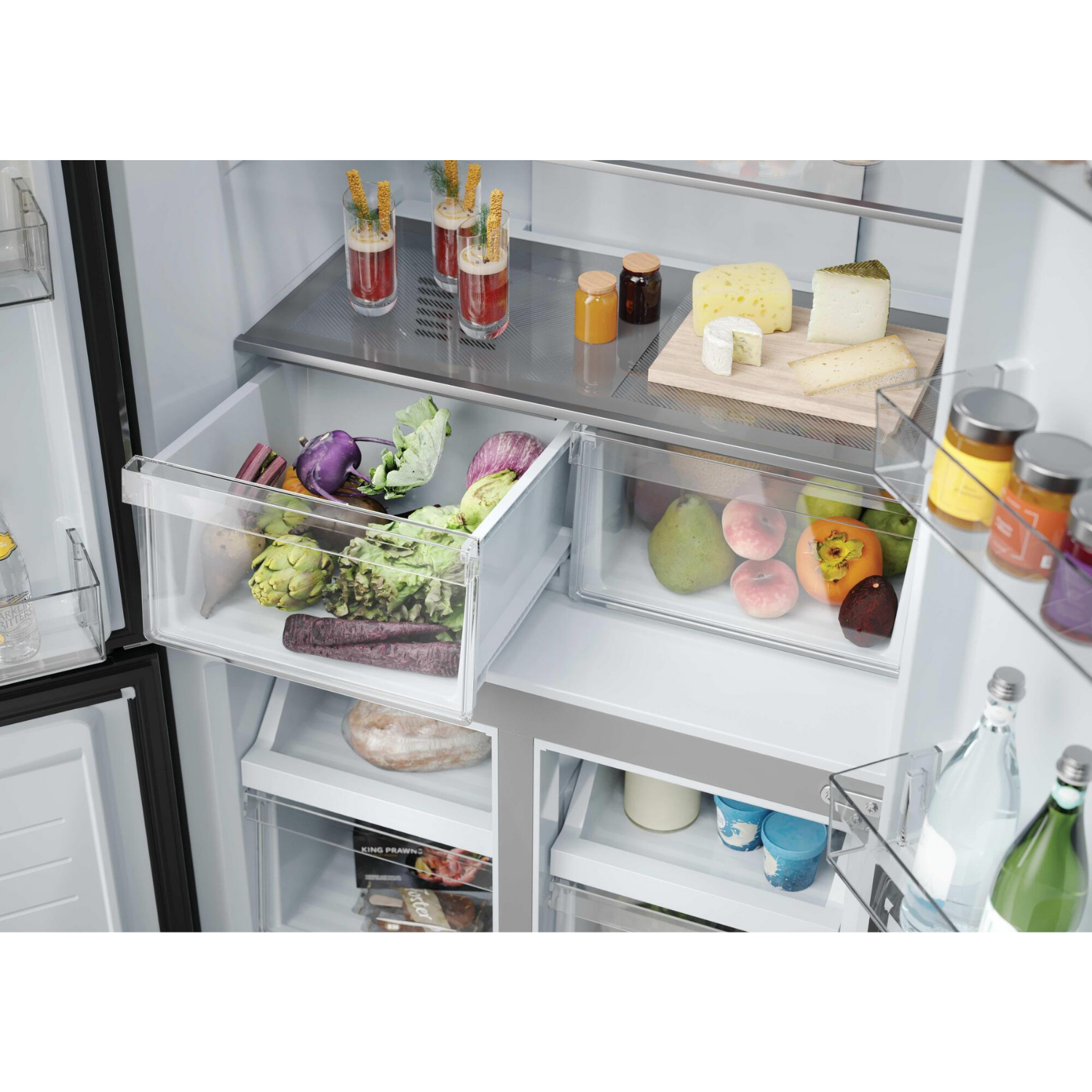 Interior de refrigerador con verduras, frutas, queso y bebidas.