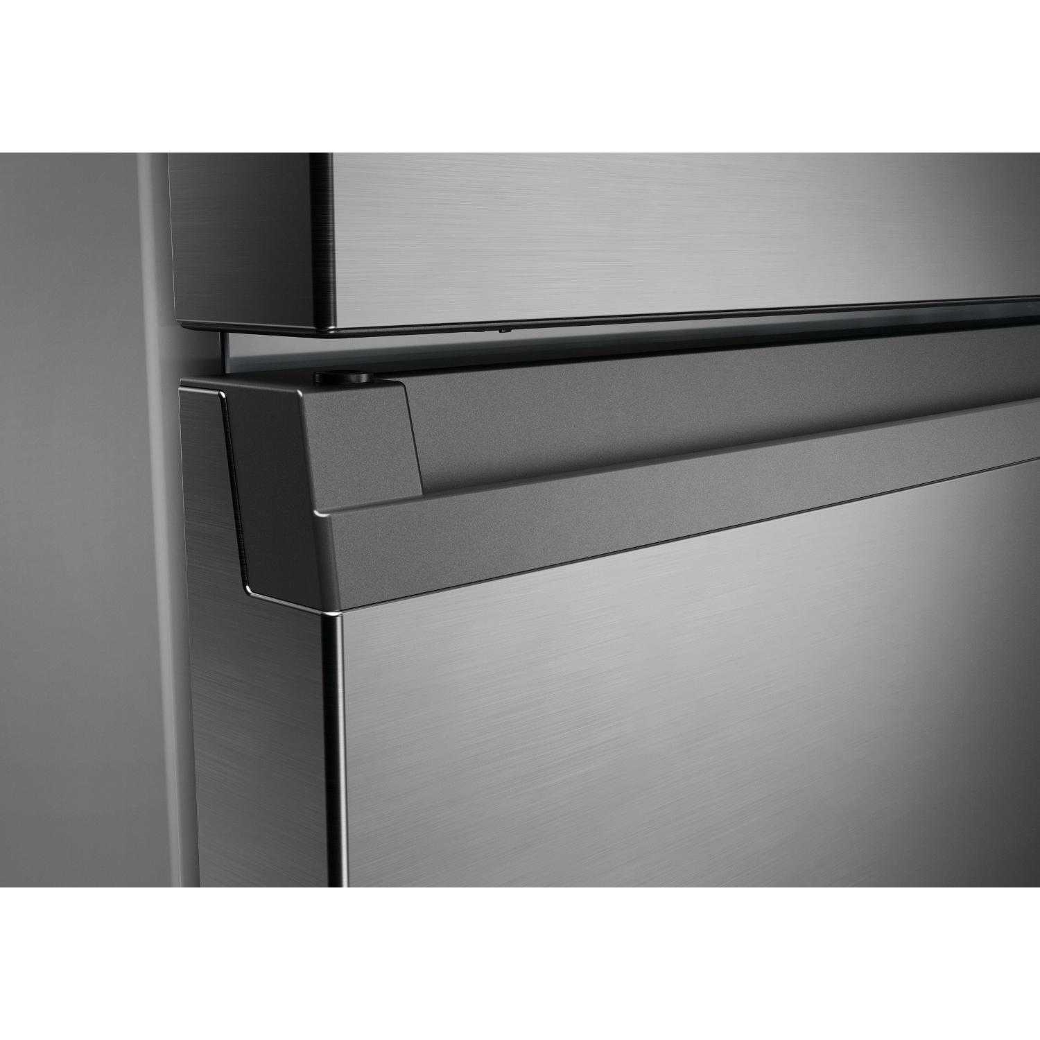 Primer plano de un tirador de frigorífico plateado y superficie de metal cepillado.