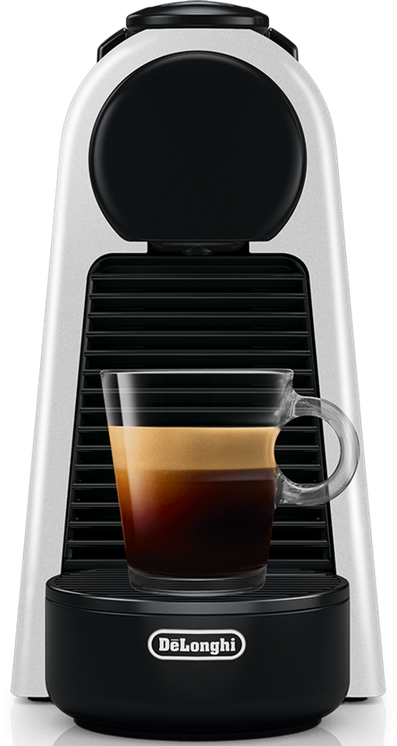 Eine weiße und schwarze Kaffeemaschine mit einem Glas Espresso darauf.