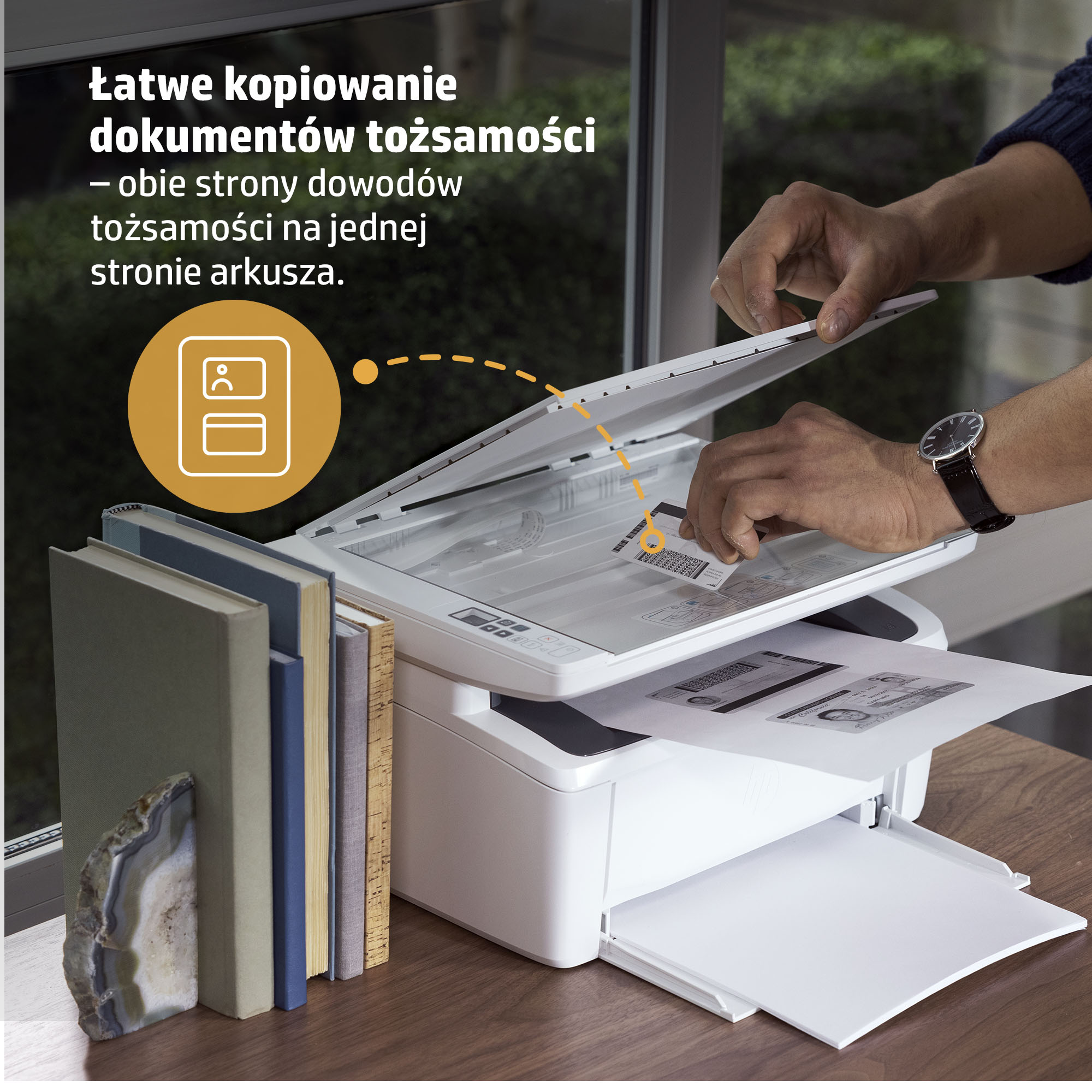 Osoba skanuje dowód tożsamości na drukarce. Książki po lewej.