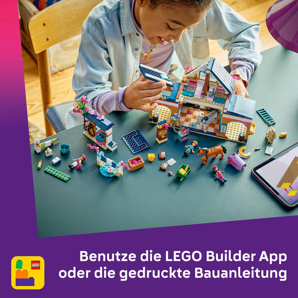Ein Kind baut ein buntes Lego-Haus mit Figuren und einem Pferd.