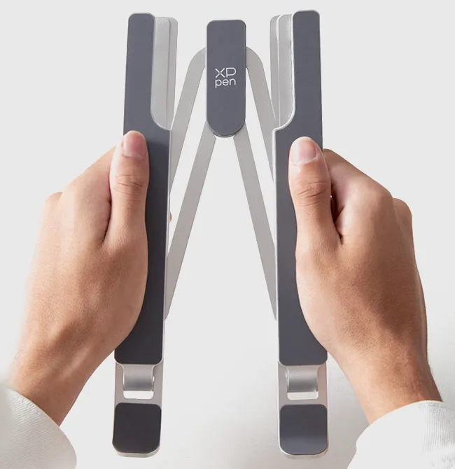 Mani che tengono un supporto pieghevole grigio per laptop.