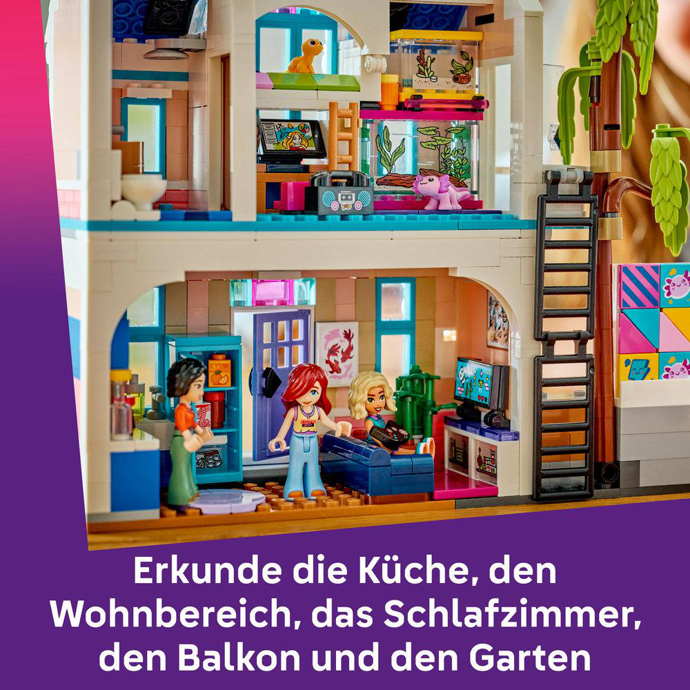 Ein Lego-Haus mit Figuren in Küche und Wohnzimmer. Dekorationen und Tiere im Obergeschoss.