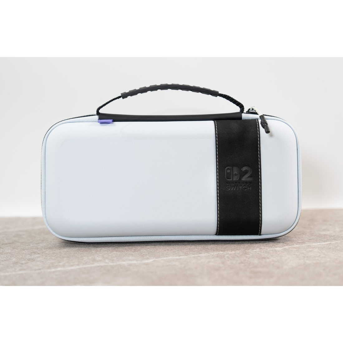 Eine weiße Nintendo Switch Tasche mit schwarzem Riemen und Logo.