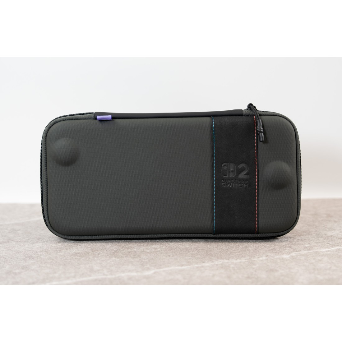 Graue Nintendo Switch Tasche mit farbigen Akzenten und Reißverschluss.