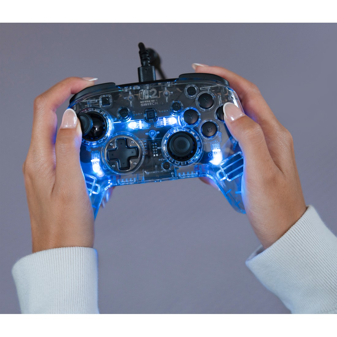 Transparenter Controller mit blauer Beleuchtung in Händen gehalten.