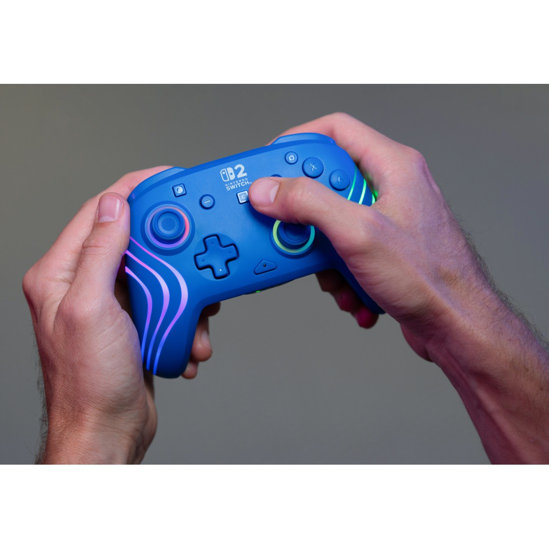 Blaue Nintendo Switch-Controller mit Lichtern, gehalten von Händen.