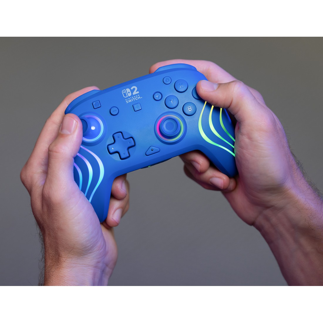 Blaue Nintendo Switch-Controller mit bunten Lichtstreifen, von Händen gehalten.
