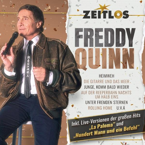 Freddy Quinn mit Mikrofon, brauner Lederjacke und Krawatte mit Schriftzug.