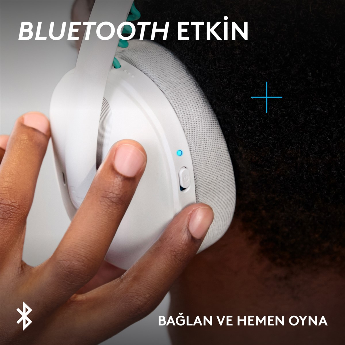 Kulaklığın yakın çekimi, el düğmeye basıyor. Mavi LED yanıyor.