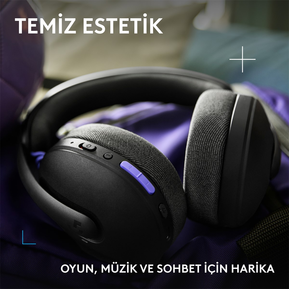 Mor aksanlı siyah kulaklık, mor bir yüzey üzerinde duruyor.