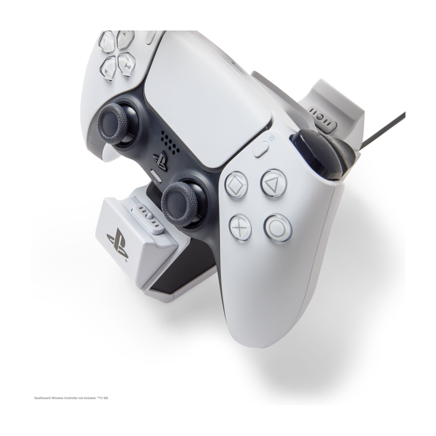 Un controller PlayStation bianco con adattatore di ricarica, su sfondo bianco.