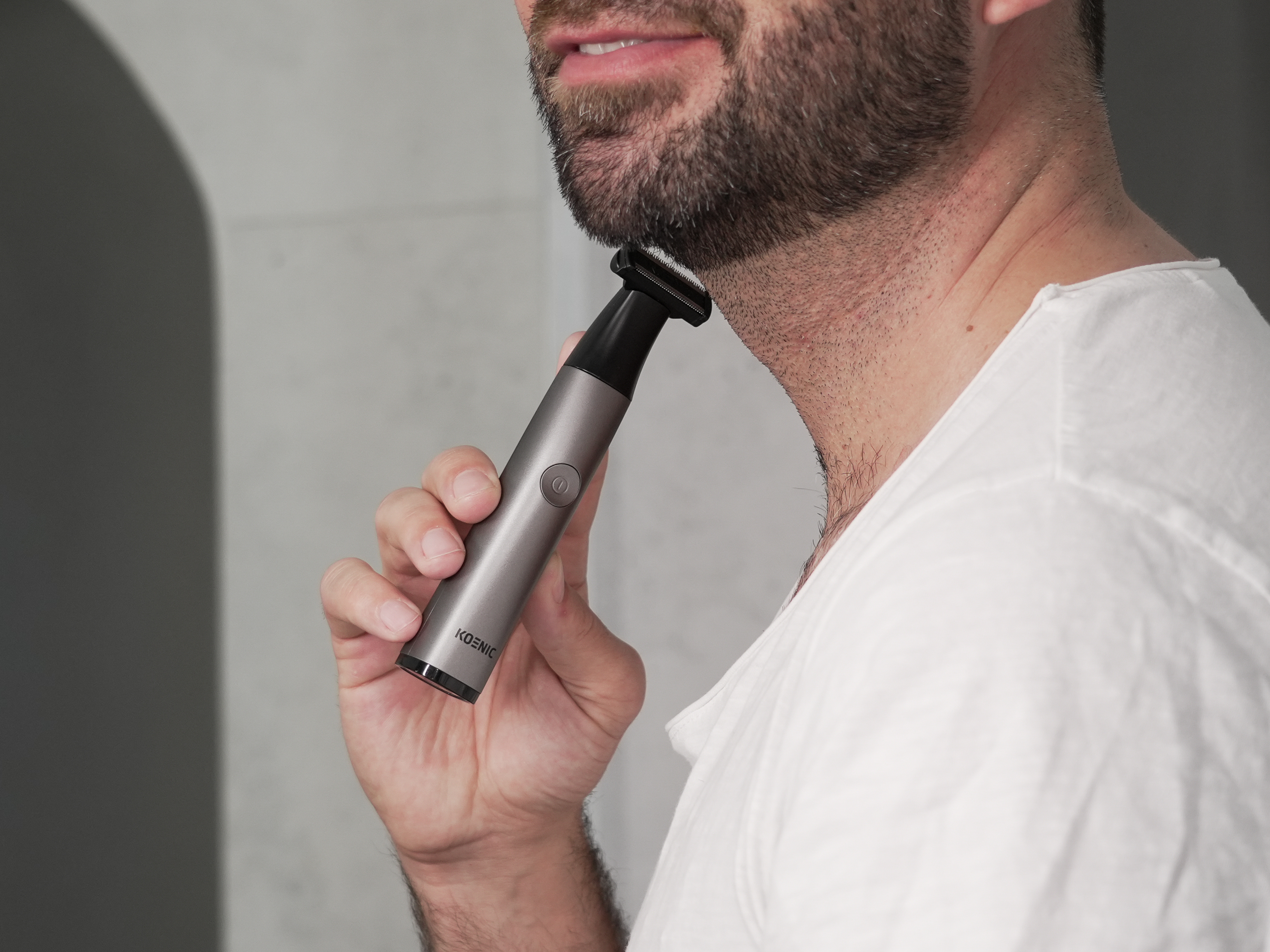 Mężczyzna przycina brodę trymerem elektrycznym. Zbliżenie.